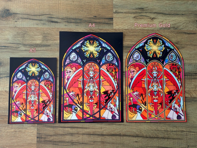 May include: Three different sizes of a print featuring a stained glass window design with a red, yellow, and blue color scheme. The window depicts a winged figure with a halo and other figures in the background. The text "A5", "A4", and "Premium Gold" are printed below each print.