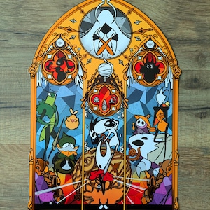 May include: A stained glass-style artwork with a gothic arch frame, depicting stylized characters. The artwork uses a vibrant colour palette with orange, blue, and red hues. The design includes various figures and geometric patterns, similar to a church window.