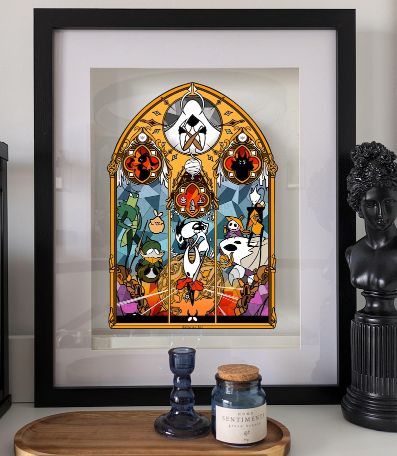 May include: Framed artwork with a stained-glass style design of cartoon characters in a black frame. The artwork has a yellow, orange, and blue colour scheme. A blue glass candle holder and a blue jar with a cork lid are in the foreground.