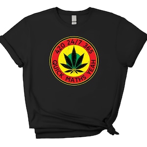 May include: Black t-shirt featuring a circular graphic with a cannabis leaf design. The graphic includes the text "420 24/7 365 YEAH QUICK MATHS" in red, yellow, and green. The shirt has a crew neck and short sleeves.