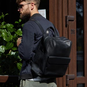 Schwarzer Lederrucksack mit Laptopfach. Schlichte Männertasche für Arbeit & Reisen. Moderne Alltagstasche. Personalisiertes Geschenk für Ihn