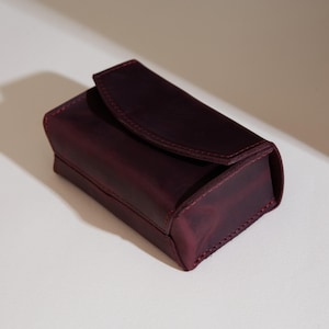 a leather wallet sitting on a white surface