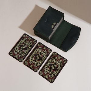 a set of four playing cards next to a wallet