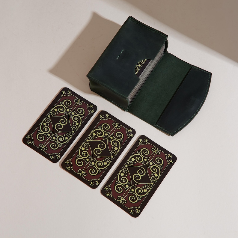 a set of four playing cards next to a wallet