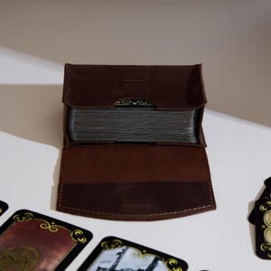 a wallet sitting on top of a table next to playing cards