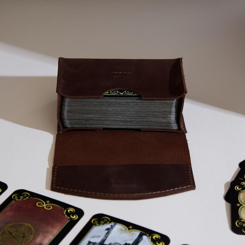 a wallet sitting on top of a table next to playing cards
