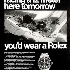May include: Vintage Rolex advertisement featuring a sailboat in action with the text "If you were racing a 12 meter here tomorrow, you'd wear a Rolex." A Rolex watch is displayed.