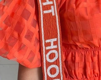 May include: Orange and white beaded bag strap with the text "FIGHT HOOK 'EM" in white.