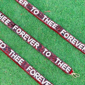 May include: Three red velvet ribbon keychains with white sequins and the text "Forever to thee Forever" repeated on each.
