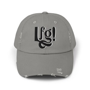 May include: A gray distressed baseball cap with the text "Lfg!" in black lettering.