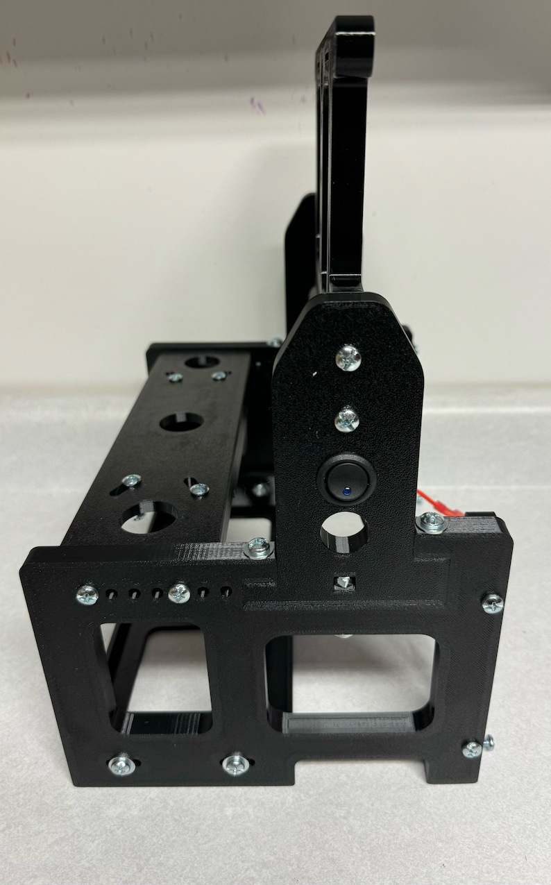 K&ouml;nnte beinhalten: Schwarzer 3D-gedruckter St&auml;nder mit einem kleinen schwarzen Schalter an der Seite. Der St&auml;nder hat mehrere L&ouml;cher und Schlitze zum Halten von Gegenst&auml;nden.