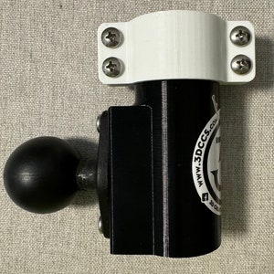 May include: A white and black 3D printed mount with a ball joint and a screw-on clamp. The mount has a logo that says "www.3dccss.com" and a small anchor symbol. The mount is designed to be attached to a surface and can be used to hold a variety of objects.