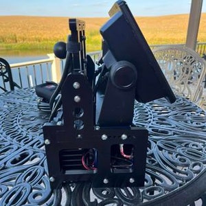 K&ouml;nnte beinhalten: Ein schwarzer Metallst&auml;nder mit zwei verstellbaren Monitoren, die darauf montiert sind. Der St&auml;nder verf&uuml;gt &uuml;ber einen K&uuml;hlventilator und ist f&uuml;r zwei Monitore ausgelegt.