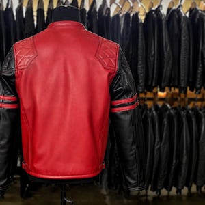 May include: A red and black leather jacket featuring a solid red back panel, black sleeves with two horizontal red stripes, and quilted diamond-patterned shoulder patches. The jacket has a mandarin collar and adjustable side waist buckles.