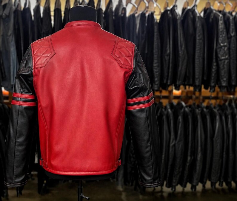 May include: A red and black leather jacket featuring a solid red back panel, black sleeves with two horizontal red stripes, and quilted diamond-patterned shoulder patches. The jacket has a mandarin collar and adjustable side waist buckles.