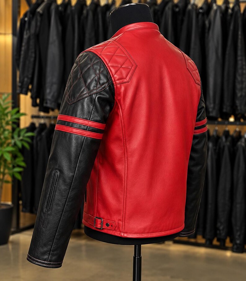 May include: A red and black leather jacket featuring a mandarin collar, quilted shoulder panels, and black sleeves with two horizontal red stripes. The jacket includes adjustable side buckles at the hem and a smooth red back panel design.