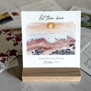 Memory Verse Scripture Card of "Let them hear" and watercolor painting artwork, along with an oak wood display stand.