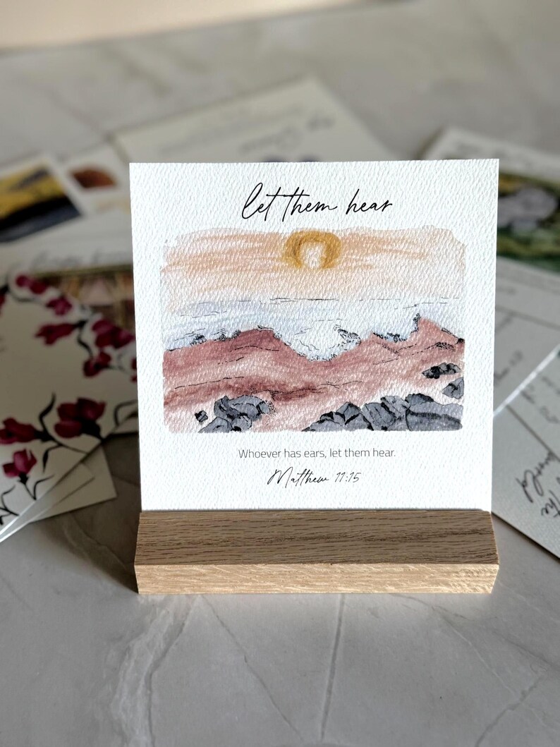 Memory Verse Scripture Card of "Let them hear" and watercolor painting artwork, along with an oak wood display stand.