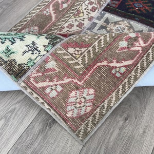 Peut inclure: Un tapis patchwork multicolore avec un motif floral. Le tapis est fait de tissu tissé et a une bordure frangée.