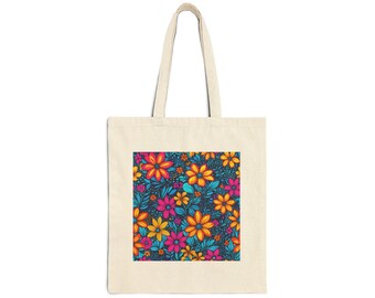 May include: Cream-colored tote bag with a vibrant floral pattern. The design features colorful flowers in shades of pink, orange, yellow, and blue against a dark blue background. The bag has a simple, rectangular shape with two handles.