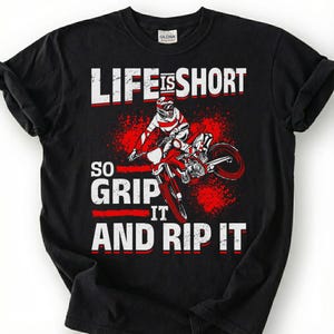 May include: Black t-shirt with a graphic of a motocross rider on a red motorcycle. The text "LIFE IS SHORT, SO GRIP IT AND RIP IT" is printed in white and red.