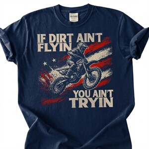 Peut inclure: T-shirt bleu marine avec un motif de pilote de motocross et le texte "IF DIRT AIN'T FLYIN YOU AIN'T TRYIN". Le design comprend un drapeau am&eacute;ricain vieilli. Le t-shirt est fait d'une mati&egrave;re douce.