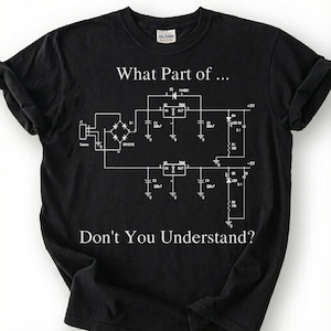 May include: Black t-shirt with white text and a circuit diagram. The text reads "What Part of... Don't You Understand?" The shirt features a crew neck and the Gildan logo on the collar. A great gift for electrical engineers and tech enthusiasts.