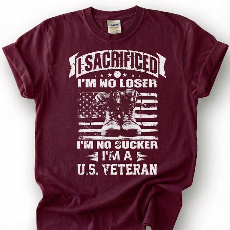 May include: Burgundy t-shirt with a graphic design. The design includes the text "I SACRIFICED I'M NO LOSER I'M NO SUCKER I'M A U.S. VETERAN" above a depiction of combat boots and an American flag.
