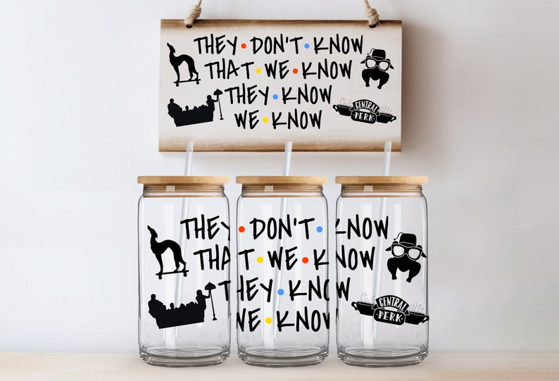 May include: Three clear glass tumblers with black and white graphics from the TV show Friends. The tumblers have a bamboo lid and a straw. The graphics include the iconic Central Perk logo, a silhouette of the Friends couch, and the phrase "They don't know that we know they know we know".