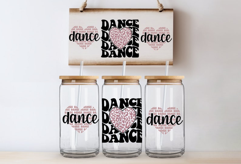 May include: Three clear glass tumblers with bamboo lids and straws. Each tumbler has a pink and black graphic with the text "DANCE" and a heart with a leopard print design.
