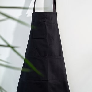 May include: A black apron with two pockets and the word "gastronomy" embroidered on the front.