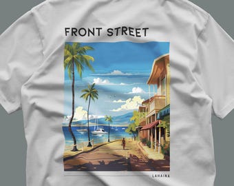 Könnte beinhalten: Ein weißes T-Shirt mit einem rechteckigen Grafikdruck auf der Rückseite. Die Illustration zeigt eine Küstenstraßenszene mit Palmen, Gebäuden, Booten auf dem Wasser sowie dem Text FRONT STREET oben und LAHAINA unten.