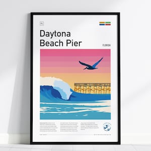 May include: A framed poster titled Daytona Beach Pier, Florida, featuring a graphic illustration of a large blue ocean wave, a wooden pier, and a flying pelican against a pink and orange sunset sky. The print includes text and a small logo.