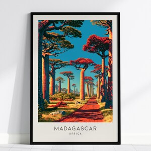 May include: A framed vertical art print featuring the Avenue of the Baobabs in Madagascar. The scene depicts tall, thick-trunked baobab trees with reddish-orange foliage under a bright blue sky, with a red dirt road leading into the distance. Text reads MADAGASCAR AFRICA.