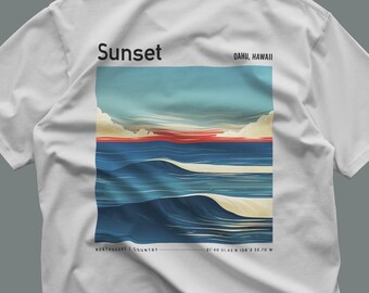 Puede incluir: Una camiseta blanca con un estampado gráfico de una puesta de sol sobre el océano. El diseño incluye el texto "Sunset" y "OAHU, HAWAII" en la parte superior, y "NORTHSHORE / COUNTRY" con las coordenadas "21 40 31.43 N 158 2 32.70 W" abajo.