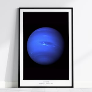May include: A framed print featuring a vibrant image of Neptune, a blue planet with swirling atmospheric patterns. The planet is set against a black background. The word "NEPTUNE" is printed at the bottom, along with the date.