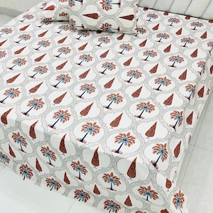 May include: White bedsheet and pillow set with a repeating pattern of stylized palm trees and teardrop shapes in shades of rust, blue, and gray. The design is set against a white background.
