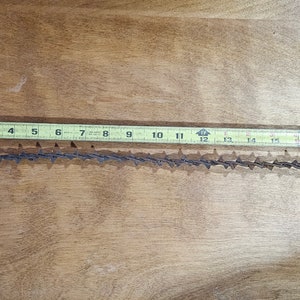 May include: A close-up of a yellow measuring tape with black markings, showing measurements from 1 to 20 inches. The tape is lying on a wooden surface.