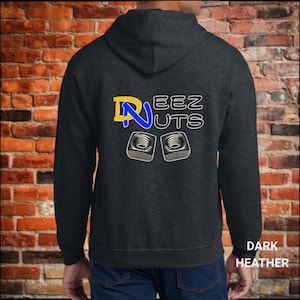 Könnte beinhalten: Dunkelgrauer Kapuzenpullover mit dem Text "Nuts" und "EEZ" in einer verspielten Schriftart. Das Design umfasst ein gelbes und blaues "N" und zwei quadratische Muttern. Die Worte "Dark Heather" sind unten aufgedruckt.