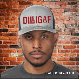 May include: A grey and black trucker cap featuring the red text "DILIGAF" on the front. The cap has a mesh back and a curved peak. The words "HEATHER GREY/BLACK" are displayed at the bottom of the image.