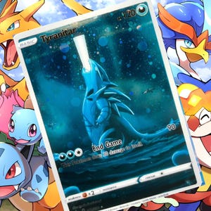 Op de afbeelding: Holografische ruilkaart met een blauwe Tyrannitar-illustratie met de tekst "End Game". De kaart is omgeven door andere kleurrijke stripfiguren, waaronder Charizard en Blastoise.