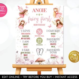 May include: A personalized fairy-themed birthday sign on an easel. The sign features illustrations of fairies, the name "Angie", and details like height (26 inches), weight (22 pounds), and favorite things. The sign includes the text "fairy first birthday".
