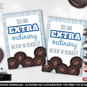 Peut inclure: Deux cartes imprimables avec le texte "YOU ARE EXTRA ordinary BELIEVE IN YOURSELF!" en bleu et blanc. Les cartes sont décorées d'un motif à carreaux bleu et de biscuits sandwich au chocolat. Une pile de biscuits et une imprimante sont également visibles.