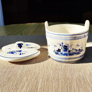 Mantequera/mostazador/mantequera redonda de cerámica de Delft con tapa, que presenta un tradicional molino de viento azul de Delft.