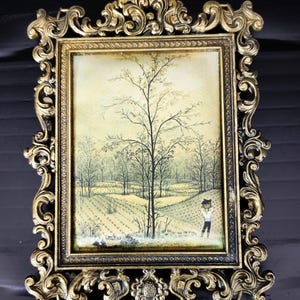 May include: An antique-style picture frame in gold, featuring a landscape scene. The print shows a field, trees, and a person. The frame has elaborate scrollwork and a detailed design, giving it a vintage look.