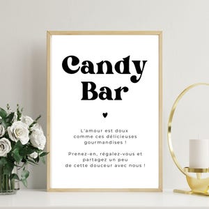 May include: A white sign with black text that reads "Candy Bar". The sign also includes the text "L'amour est doux comme ces délicieuses gourmandises! Prenez-en, régalez-vous et partagez un peu de cette douceur avec nous!"