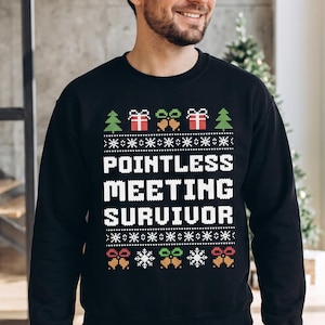 May include: A black long-sleeve sweatshirt featuring a white pixelated graphic that reads "POINTLESS MEETING SURVIVOR" in the center. The design includes festive holiday motifs like green pine trees, red gift boxes, gold bells, and white snowflakes.