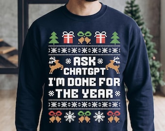 May include: A navy blue long-sleeve sweatshirt featuring a white, red, green, and yellow pixelated holiday pattern. The center text reads ASK CHATGPT I'M DONE FOR THE YEAR, surrounded by graphic icons of Christmas trees, gifts, bells, and snowflakes.