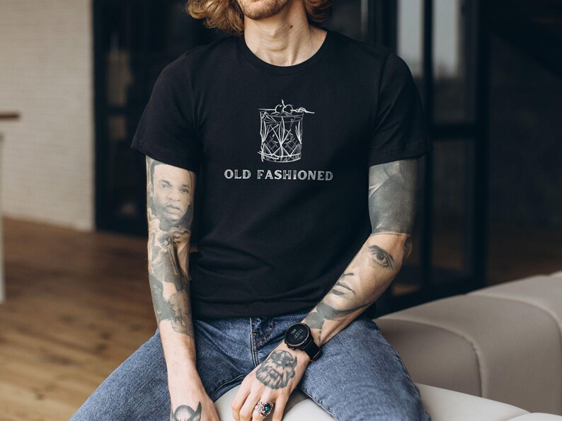 May include: A black t-shirt with a white graphic of an old fashioned cocktail and the text "OLD FASHIONED".