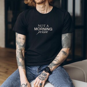 Pu&ograve; includere: Una maglietta nera con la scritta "NOT A MORNING person" in lettere bianche.